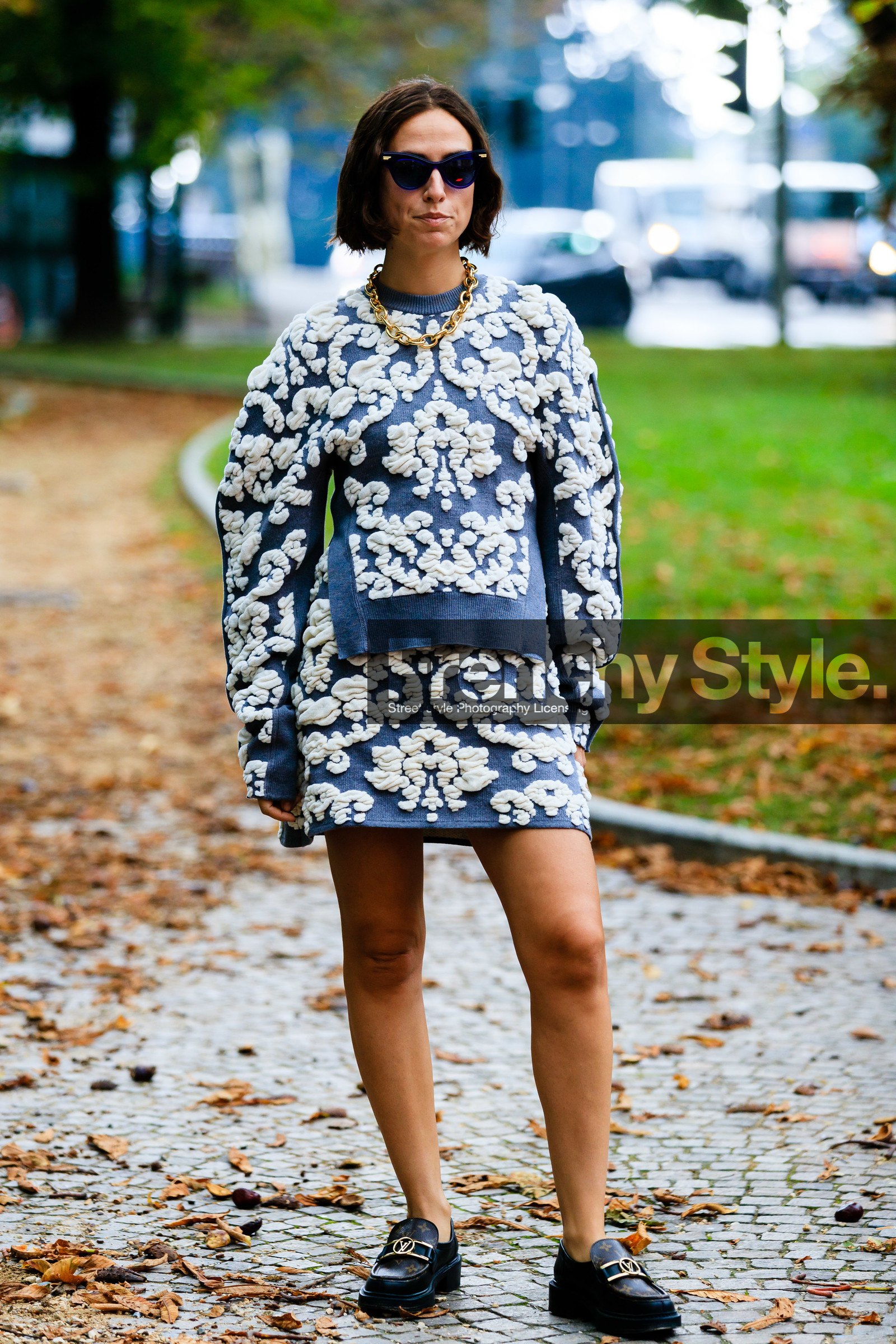 knit skirt, knitwear, mini skirt, blue skirt, blue pullover, floral embroidered skirt, floral embroidered pullover, white skirt, white pullover, brown leather loafers, black leather loafers, monogrammed shoes, monogrammed loafers, louis vuitton shoes, flat shoes, oversize shoulder, blue sunglasses, bottega veneta sunglasses, velvet skirt, velvet bag, big chain necklace, golden necklace, erika boldrin, street style, jonathan paciullo, FW, frenchystyle, fashion week, MFW, MILAN, SPRING SUMMER 2021, SS 21, vertical, full length