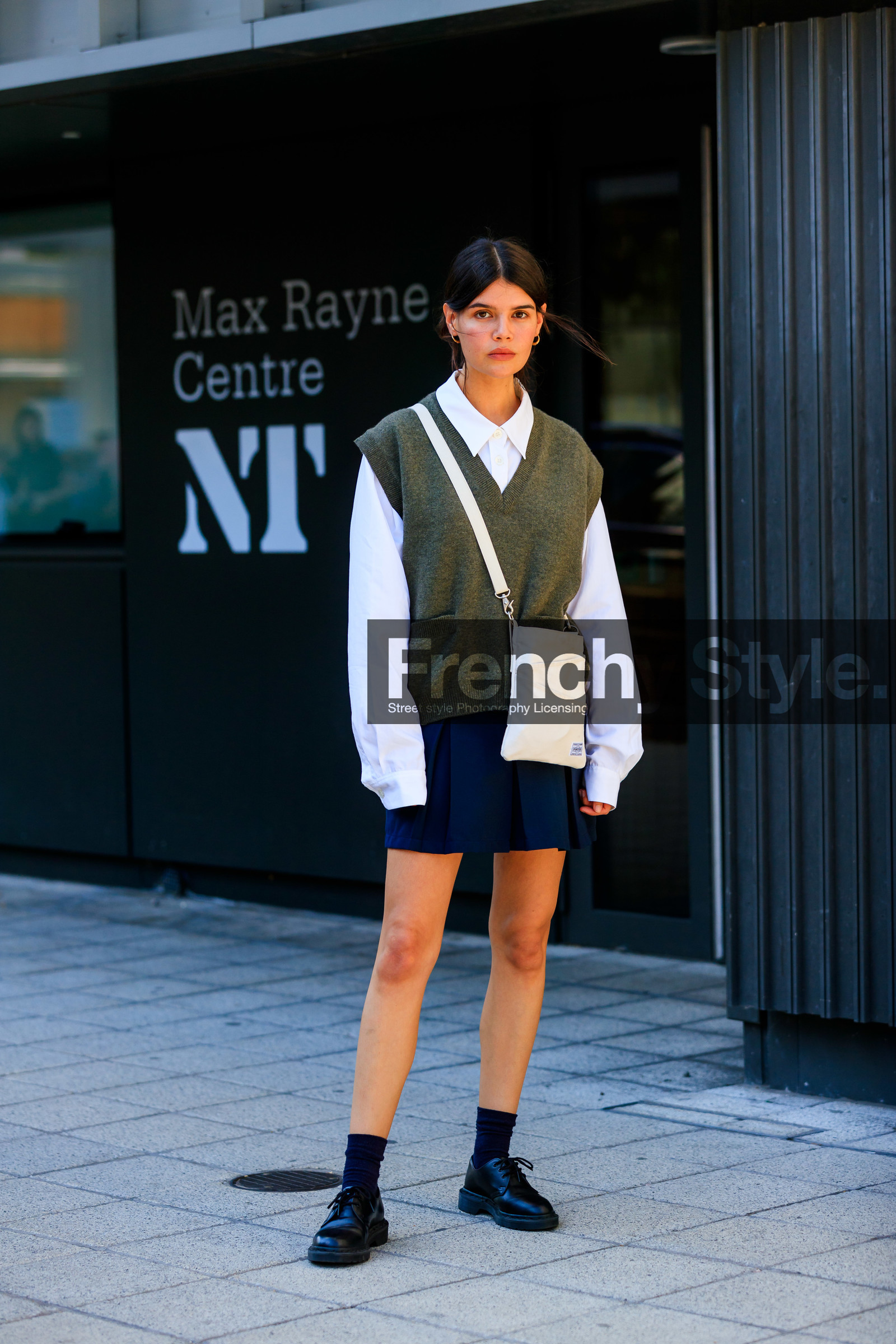 school girl look, white shirt, oversize shirt, knitwear, sleeveless pullover, kaki pullover, man style pullover, porter bag, crossbody bag, black and white bag, square shape bag, navy blue skirt, pleated skirt, black socks, doc marteens shoes, laced shoes, black leather shoes, long sleeves shirt, oversize sleeves, hoop earrings, golden earrings, fashion week, frenchystyle, FW, jonathan paciullo, street style, vertical, full length