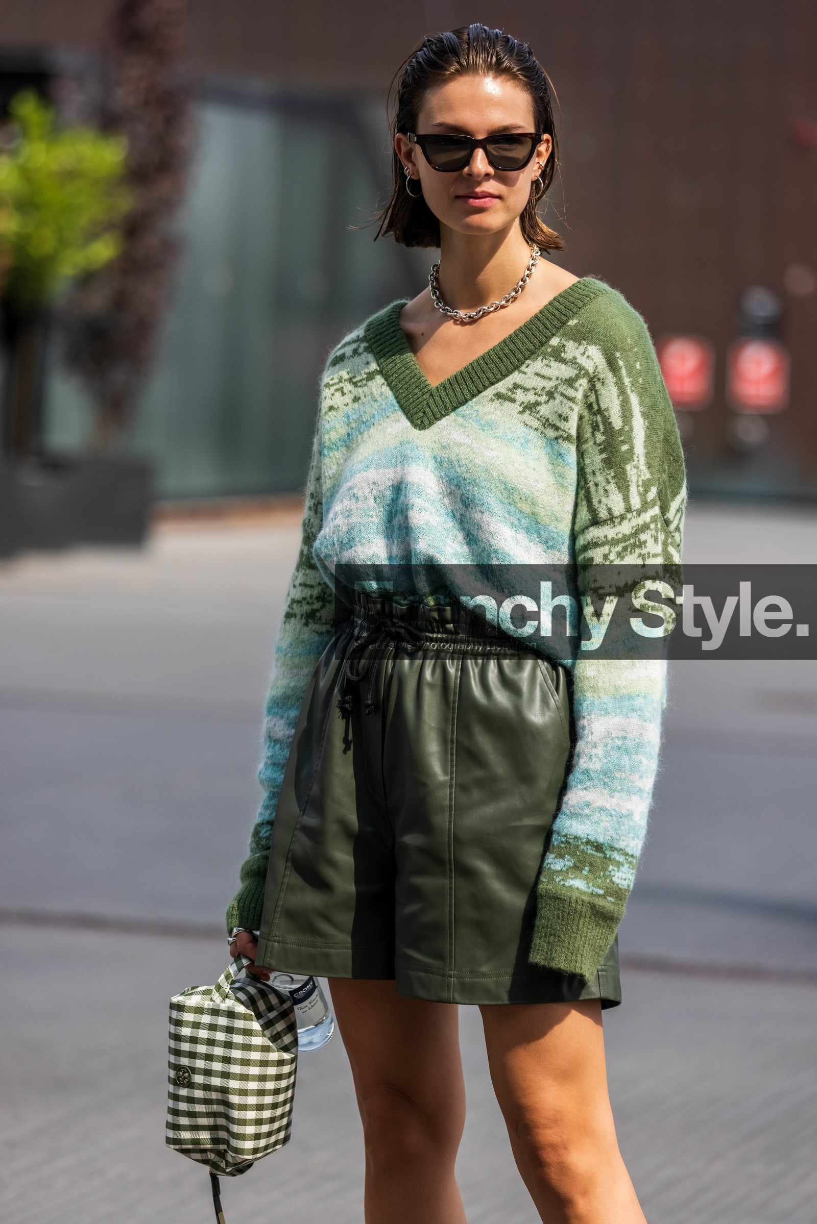 Jacqueline Zelwis, kaki pullover, kaki shorts, kaki leather shorts, green leather shorts, green pullover, jacquard pullover, striped pullover, tie and dye pullover, low necked pullover, loose pullover, light blue pullover, kaki clutch, white clutch, vichy printed clutch, bicolor clutch, tory burch bag, tory burch clutch, silver necklace, silvered earrings, silvered necklace, hoop earrings, big chain necklace, multi earrings, black sunglasses, square shape glasses, fashion week, frenchystyle, FW, jonathan paciullo, street style, SPRING SUMMER 2022, SS 22, COPENHAGEN, CPHFW, vertical, atmosphere details