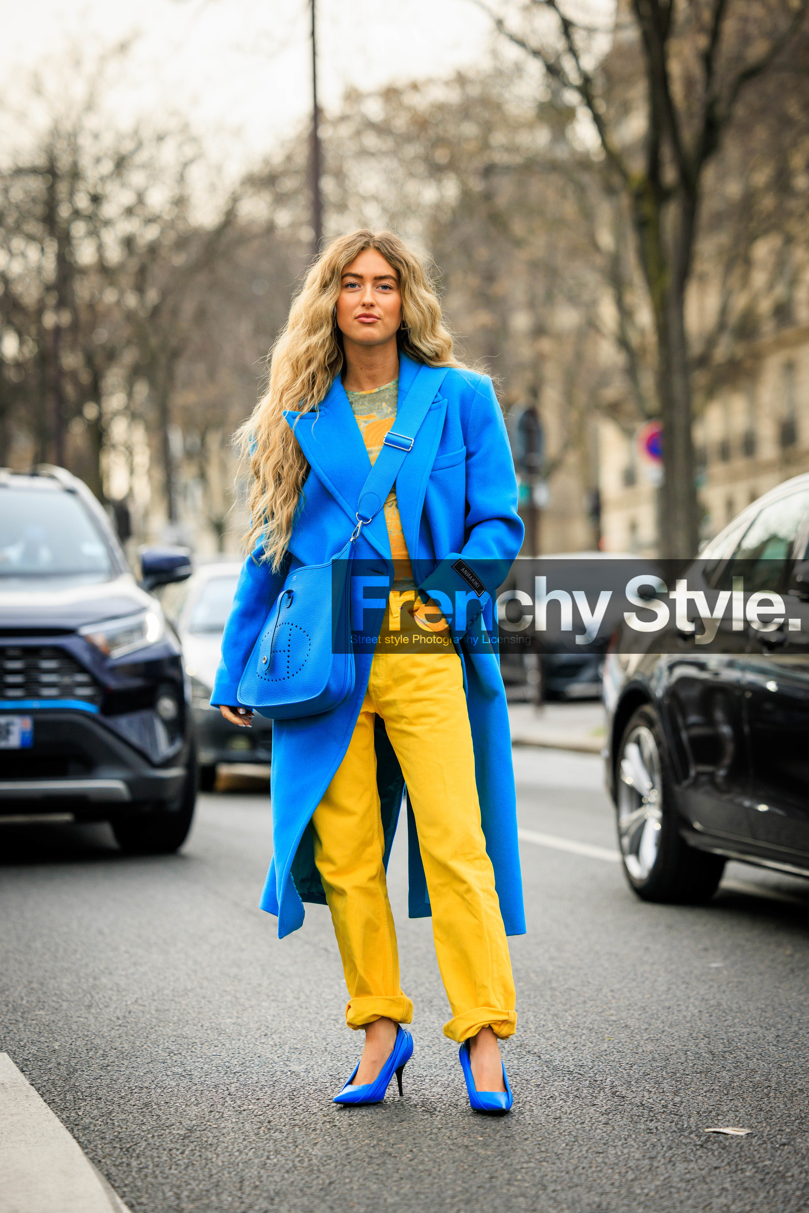 blue heels, blue stilettos, printed top, yellow top, blue coat, hermes bag, leather bag, curly hair, blond, longhair, yellow pants, denim, emili sindlev, street style, jonathan paciullo, FW, frenchystyle, fashion week, AUTUMN WINTER 2022-2023, FALL WINTER 2022_2023, FW 22-23, PFW, PARIS, full length, vertical, crossbody bag