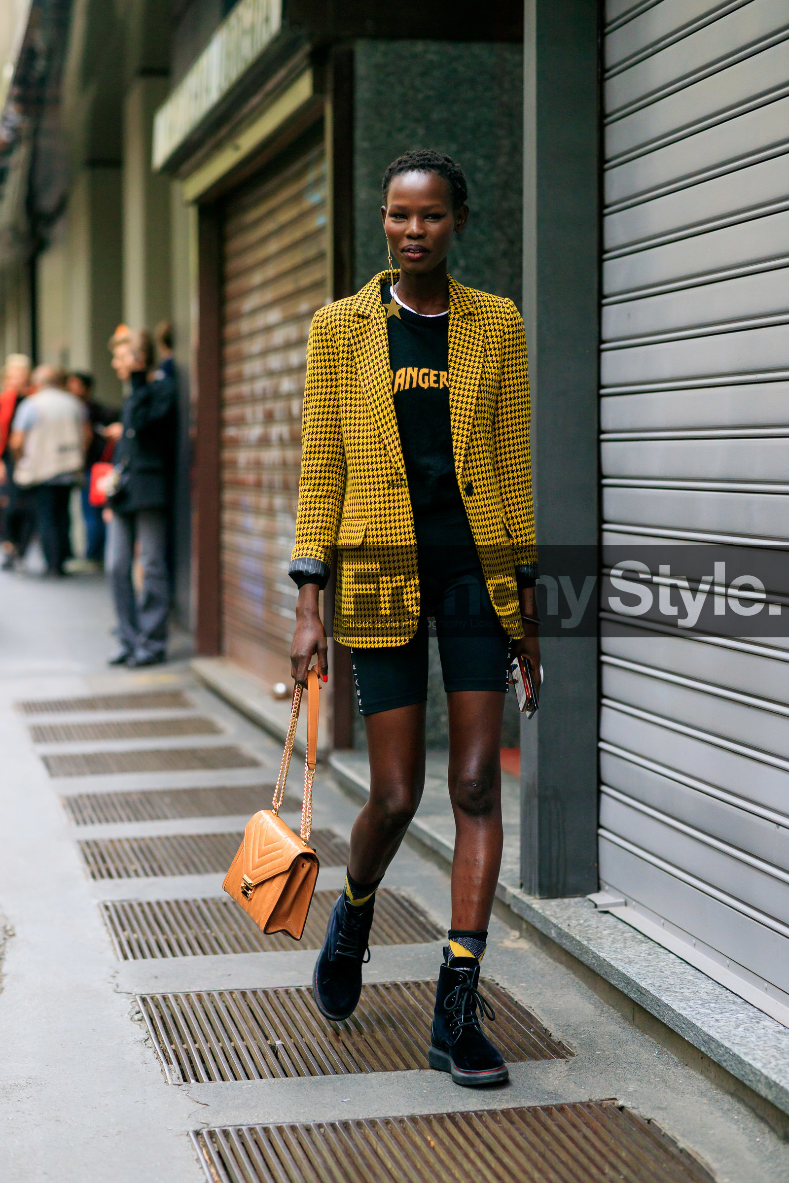 model, Shanelle Nyasiase, yellow jacket, checked jacket, black t-shirt, black shorts, black suede boots, tight shorts, nike shorts, laced boots, camel leather bag, golden chain strap bag, quilted bag, alexander mcqueen shoes, golden earrings, sportswear shorts, black eyeliner, eye make up, make up, make up details, black hat, brown leather bag, fashion week, frenchystyle, FW, jonathan paciullo, street style, vertical, full length, MFW, MILAN, SPRING SUMMER 2020, SS 20