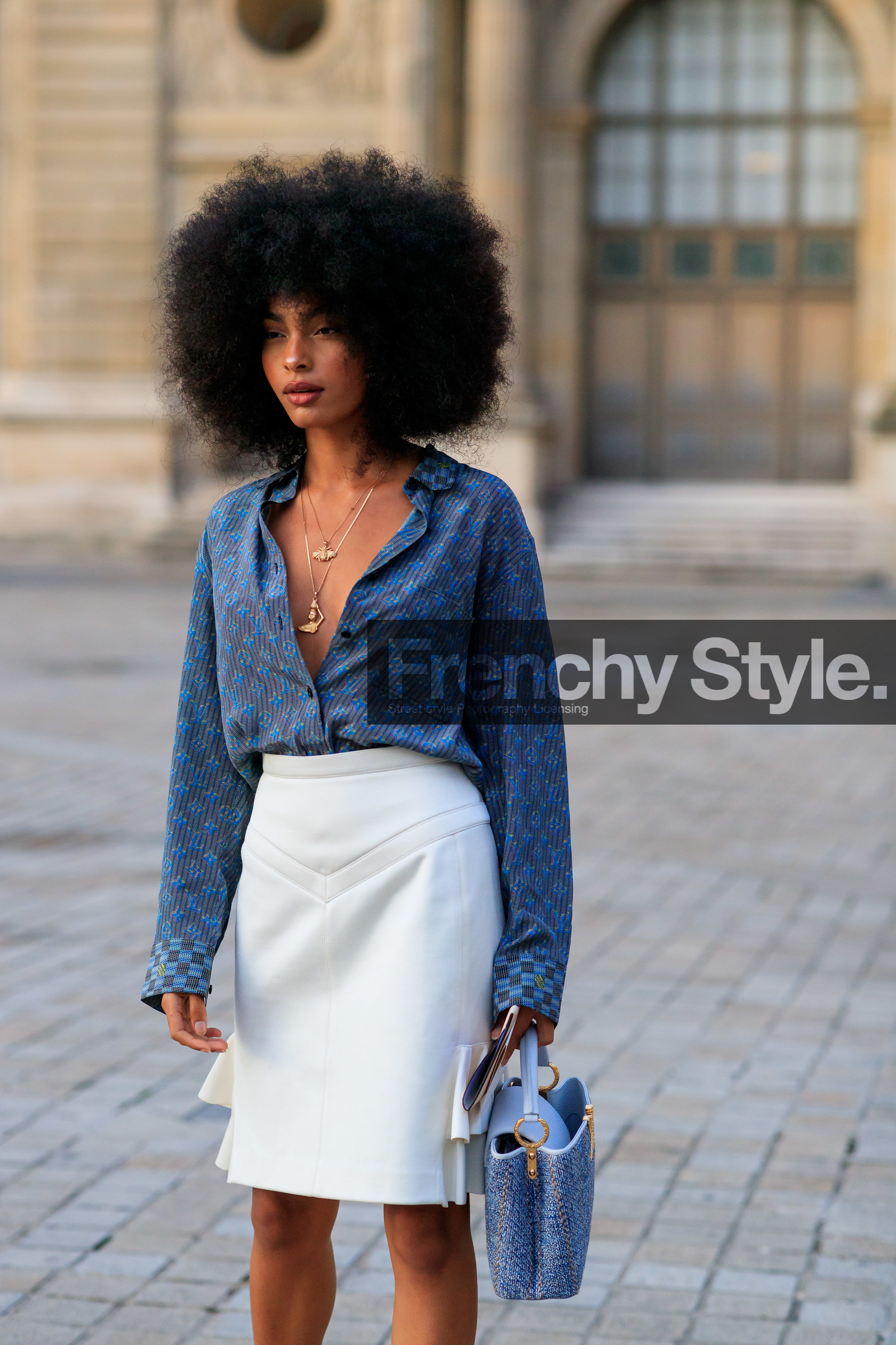 sharon alexie, blue shirt, blue bag, monogrammed shirt, low necked shirt, white skirt, ruffle skirt, mini skirt, hand bag, tweed bag, long necklace, golden necklace, animal shape necklace, charms necklace, louis vuitton bag, louis vuitton necklace, louis vuitton shirt, louis vuitton skirt, louis vuitton total look, white leather bag, PARIS, PFW, SPRING SUMMER 2020, SS 20, fashion week, frenchystyle, FW, jonathan paciullo, street style, vertical, atmosphere details, detail