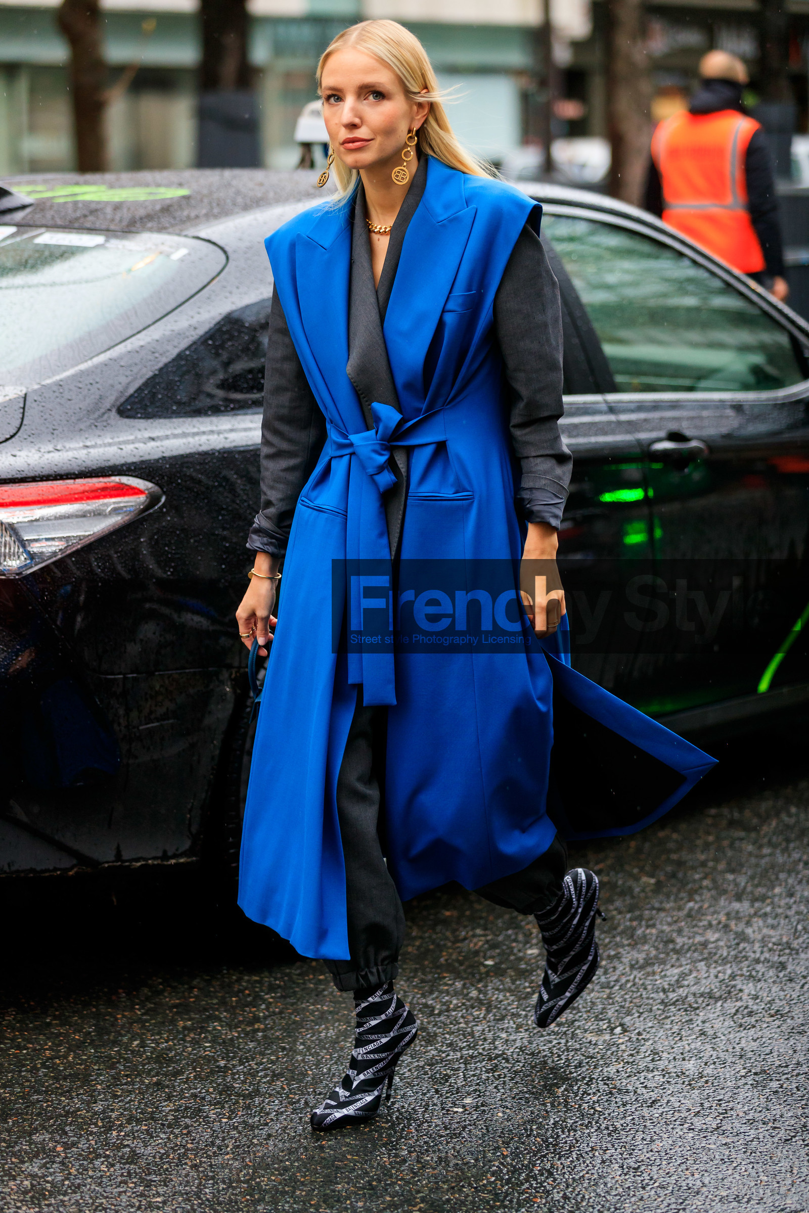 leonie hanne, blue jacket, long jacket, grey jacket, grey pants, sleeveless jacket, belted jacket, golden earrings, dangling earrings, golden necklace, big chain necklace, balenciaga earrings, balenciaga jacket, balenciaga boots, black leather boots, logo printed boots, low boots, striped boots, monogrammed boots, high heels boots, socks boots, fashion week, frenchystyle, FW, jonathan paciullo, street style, PFW, PARIS, vertical, full length