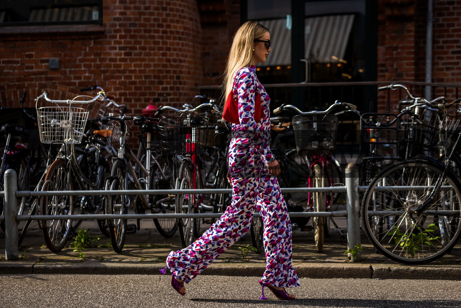amina muaddi shoes, bag, color, fluid pants, large pants, mules, pants, print, printed pants, printed top, purple mules, purple pants, purple sandals, purple top, red bag, sandals, fashion week, frenchystyle, FW, jonathan paciullo, street style, SPRING SUMMER 2022, SS 22, COPENHAGEN, CPHFW, atmosphere details, horizontal, full length