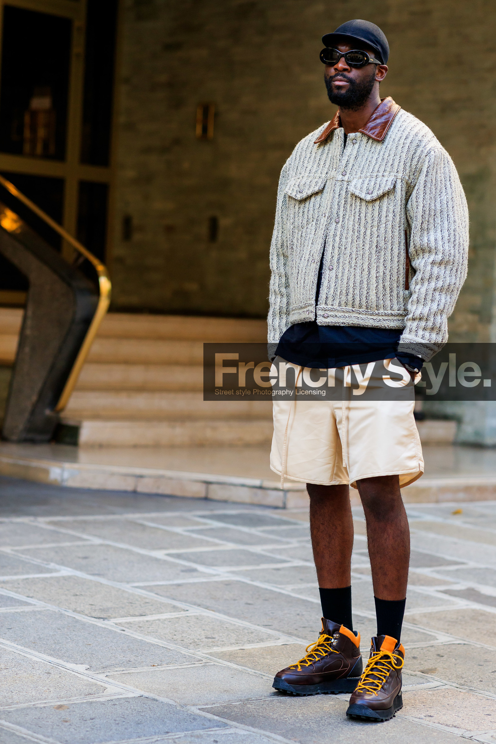 tweed jacket, button jacket, leather collar, beige jacket, beige shorts, light beige shorts, striped jacket, kaki jacket, black cap, black sunglasses, round shape sunglasses, brown leather boots, hiking boots, orange boots, big sole boots, laced boots, jean phillipe phiné n'djoli, fashion week, frenchystyle, FW, jonathan paciullo, street style, PFW, PARIS, SPRING SUMMER 2022, SS 22, vertical, full length