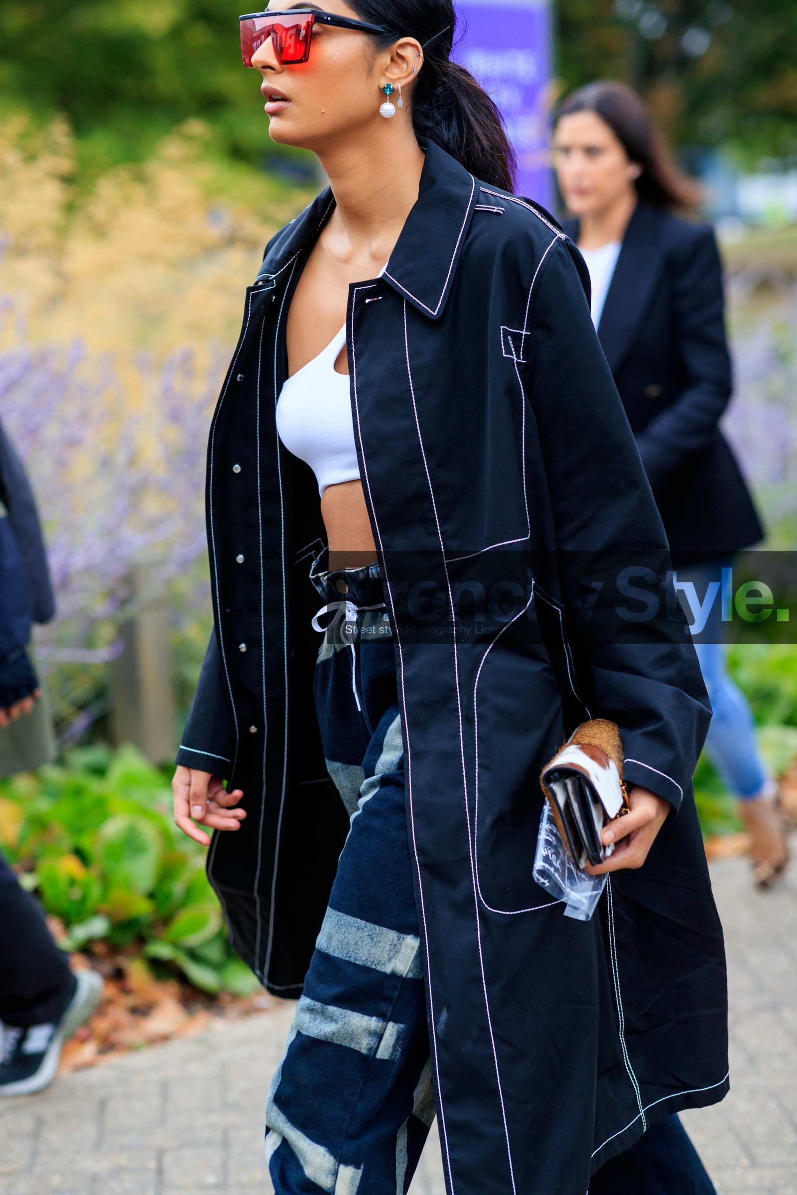 black coat, black trench coat, white bra, cropped top, red sunglasses, futurist shape sunglasses, tie and dye pants, high waist pants, blue jeans, denim, pearl earrings, dangling earrings, fashion week, frenchystyle, FW, jonathan paciullo, street style, vertical, detail, atmosphere details