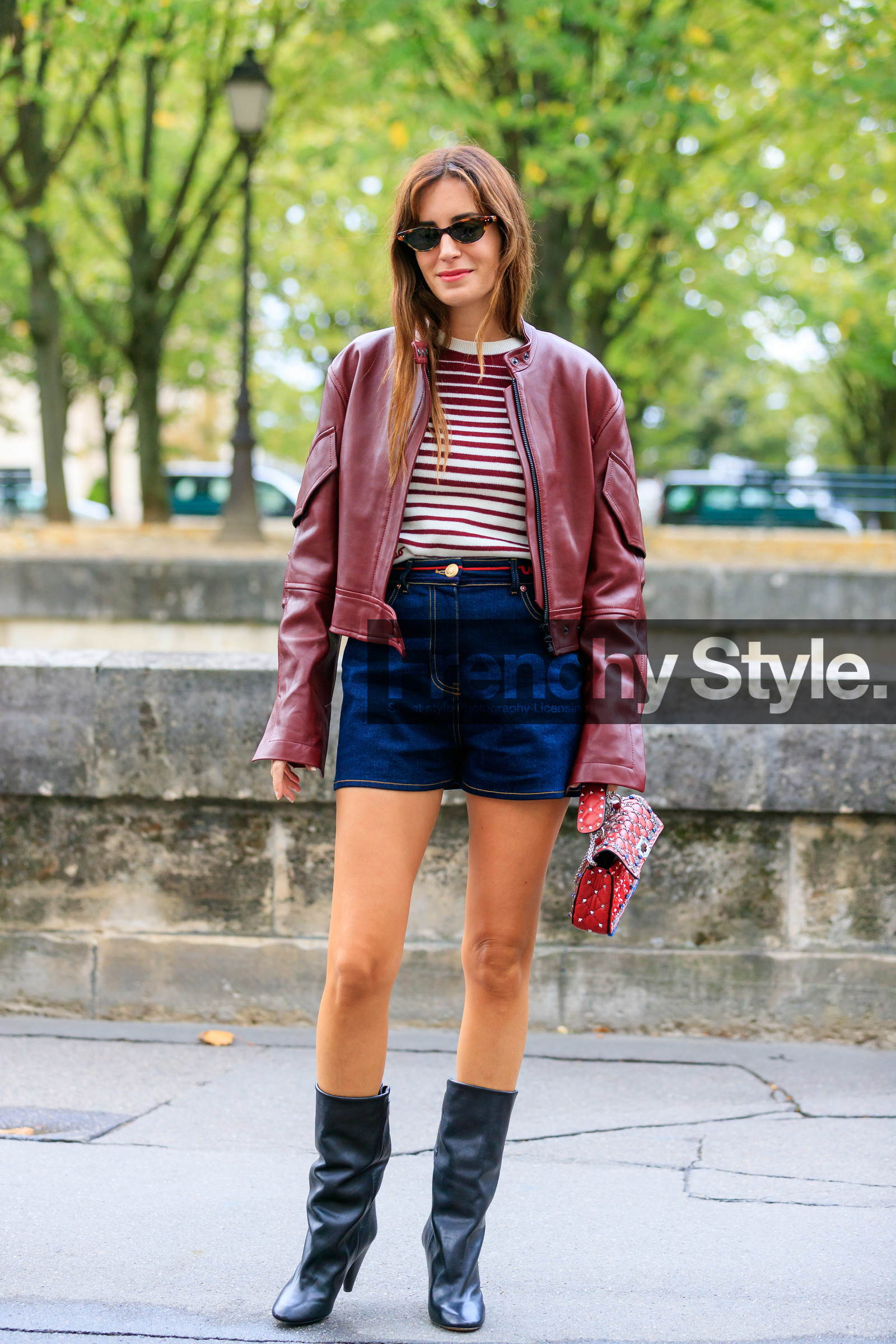 gala gonzalez, burgundy leather jacket, burgundy pullover, white pullover, striped pullover, red leather bag, valentino bag, denim shorts, navy blue shorts, high waist shorts, studs details bag, strassed bag, small sunglasses, scale sunglasses, black leather boots, valentino look, valentino pullover, valentino shorts, PARIS, PFW, SPRING SUMMER 2020, SS 20, fashion week, frenchystyle, FW, jonathan paciullo, street style, vertical, full length