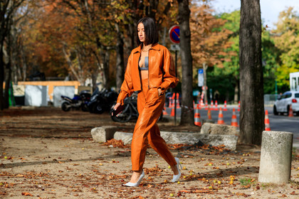 alexandra guerain, orange leather jacket, orange leather pants, orange total look, zipped jacket, black bra, cropped top, low necked top, black leather top, multi necklace, chain necklace, letters necklace, golden necklace, white leather shoes, acne studios shoes, PARIS, PFW, SPRING SUMMER 2020, SS 20, fashion week, frenchystyle, FW, jonathan paciullo, street style, horizontal, atmosphere details, full length