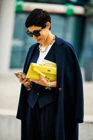 hermes clutch, yellow clutch, pencil bag, blue coat, blue striped vest, blue suit, full blue look, dark blue pants, white straight pants, black sunglasses, golden chain necklace, eye bracelets, golden bracelets, iphone, grey nails, short hair, white tshirt, street style, jonathan paciullo, FW, frenchystyle, fashion week, MFW, MILAN, FALL WINTER 2022_2023, AUTUMN WINTER 2022-2023, FW 22-23, vertical, atmosphere details