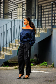 bomber jacket, golden stud earrings, orange turtleneck, black trousers, black stilettos, dark blue jacket, coperni, tina kunakey, street style, jonathan paciullo, FW, frenchystyle, fashion week, AUTUMN WINTER 2022-2023, FALL WINTER 2022_2023, FW 22-23, PFW, PARIS, full length, vertical