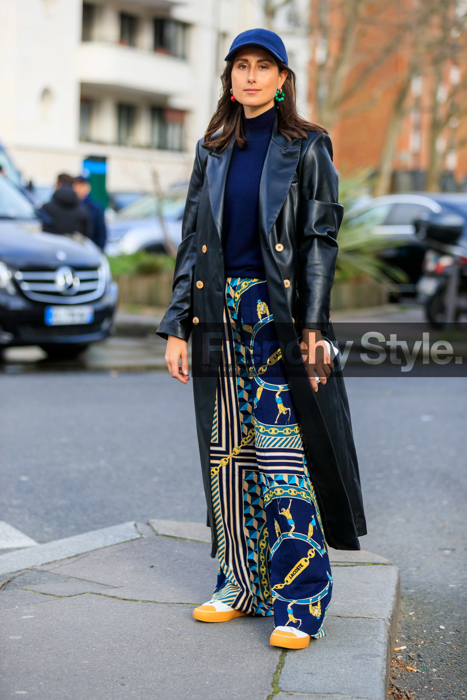 julia haghjoo, navy blue cap, navy blue pullover, navy blue pants, black leather jacket, black leather trench coat, long jacket, printed pants, green pants, yellow pants, striped pants, geometrical printed pants, lacoste pants, lacoste cap, lacoste shoes, green earrings, red earring, different earrings, round shape earrings, dangling earrings, fashion week, frenchystyle, FW, jonathan paciullo, street style, PFW, PARIS, vertical, full length