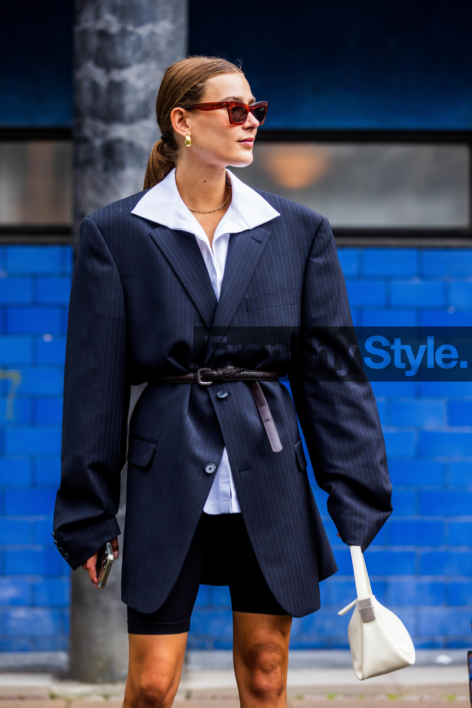Vera Van Erp, navy blue jacket, striped jacket, oversize jacket, belted jacket, black leather belt, white shirt, black shorts, legging shorts, black legging, black legging shorts, golden earrings, golden necklace, hoop earrings, chain necklace, white leather bag, eyecat sunglasses, celine sunglasses, fashion week, frenchystyle, FW, jonathan paciullo, street style, SPRING SUMMER 2022, SS 22, COPENHAGEN, CPHFW, vertical, atmosphere details