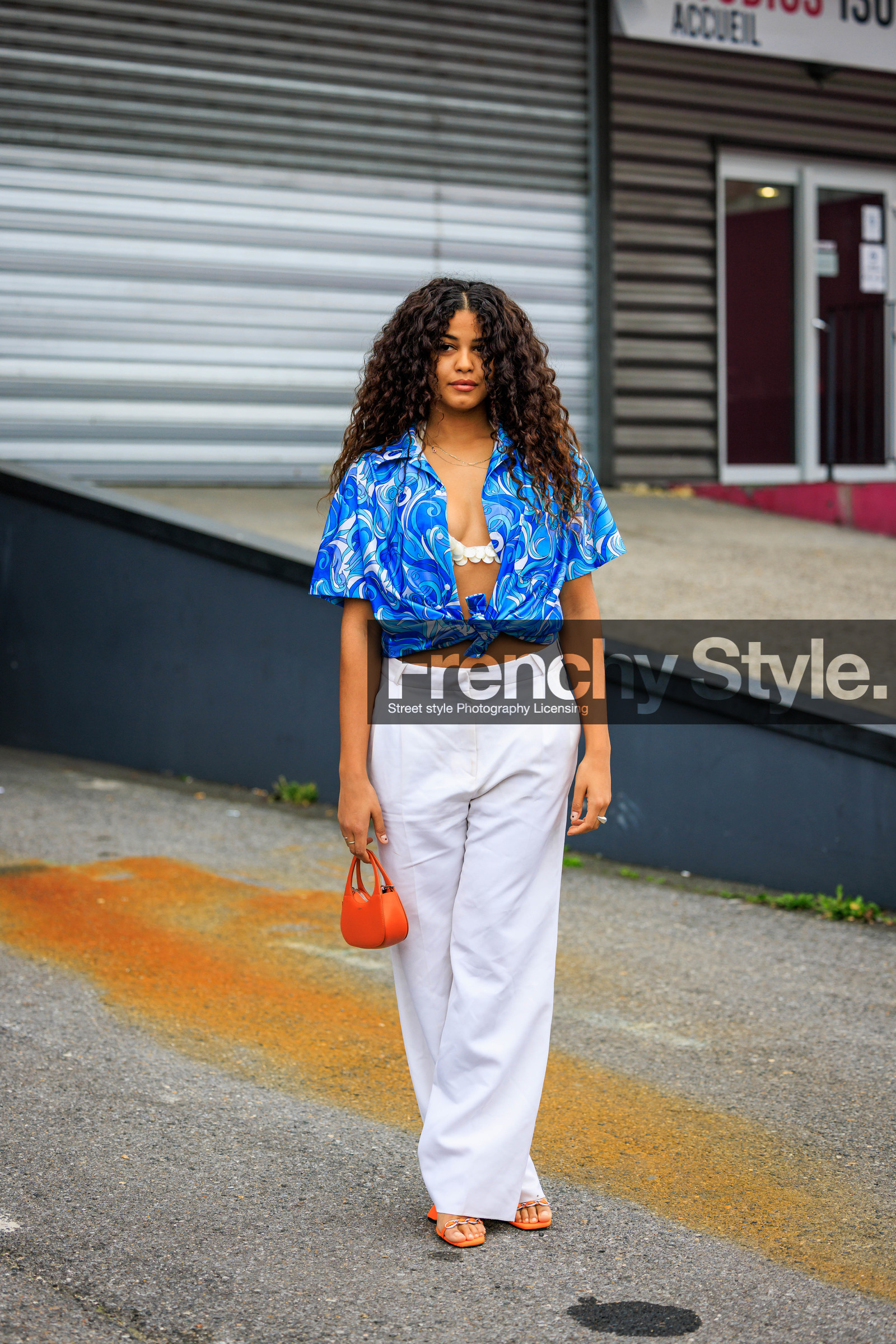 curly hair, blue shirt, printed shirt, coperni shirt, white bra, white trousers, baggy trousers, orange bag, mini bag, orange sandals, coperni, street style, jonathan paciullo, FW, frenchystyle, fashion week, AUTUMN WINTER 2022-2023, FALL WINTER 2022_2023, FW 22-23, PFW, PARIS, full length, vertical