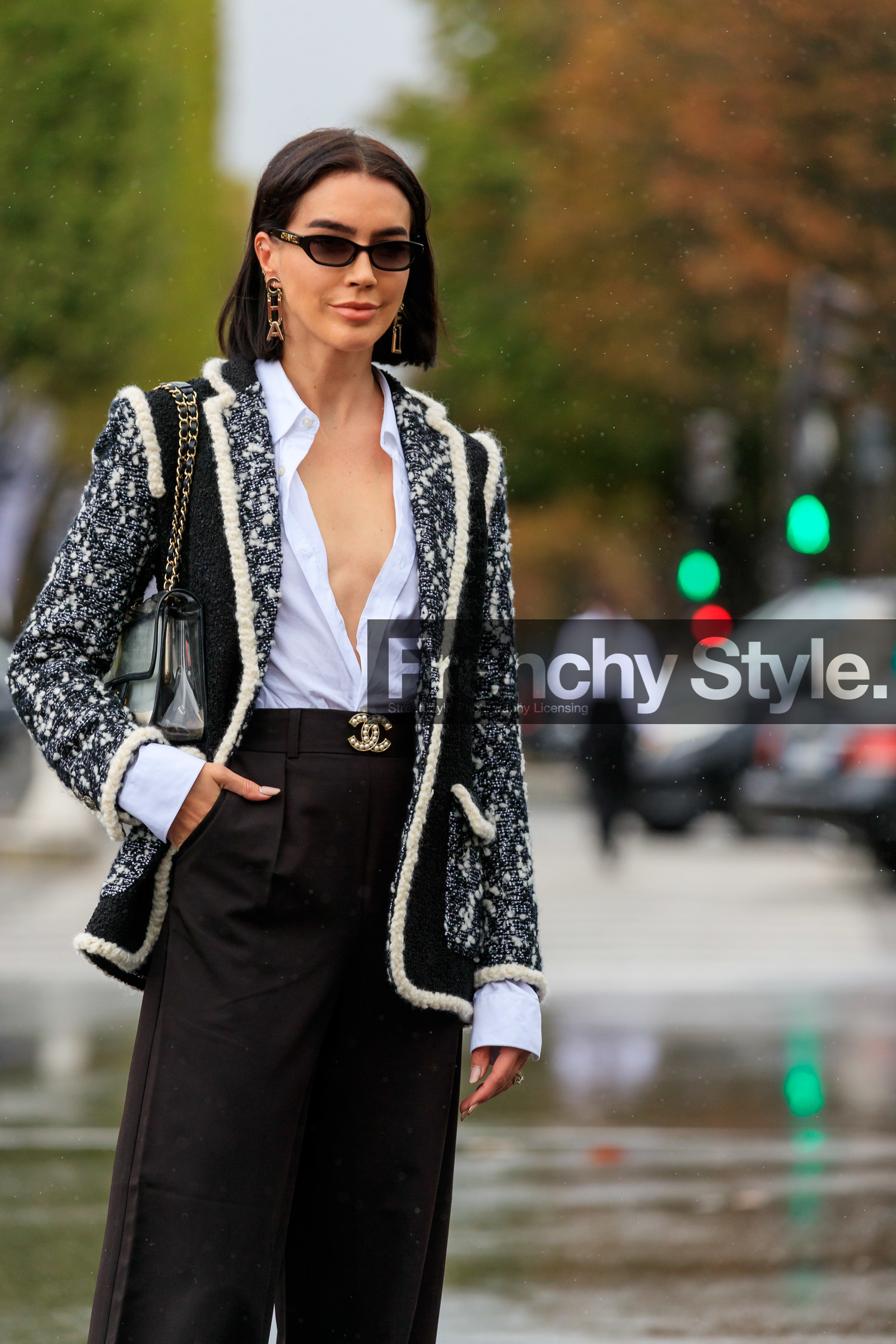 brittany xavier, chanel bag, chanel jacket, chanel earrings, chanel belt, chanel sunglasses, chanel total look, white shirt, low necked shirt, black jacket, white jacket, tweed jacket, golden earrings, letters earrings, dangling earrings, black pants, plastic bag, sheer bag, chain strap bag, loose pants, prada shoes, flare pants, PARIS, PFW, SPRING SUMMER 2020, SS 20, fashion week, frenchystyle, FW, jonathan paciullo, street style, vertical, atmosphere details, detail