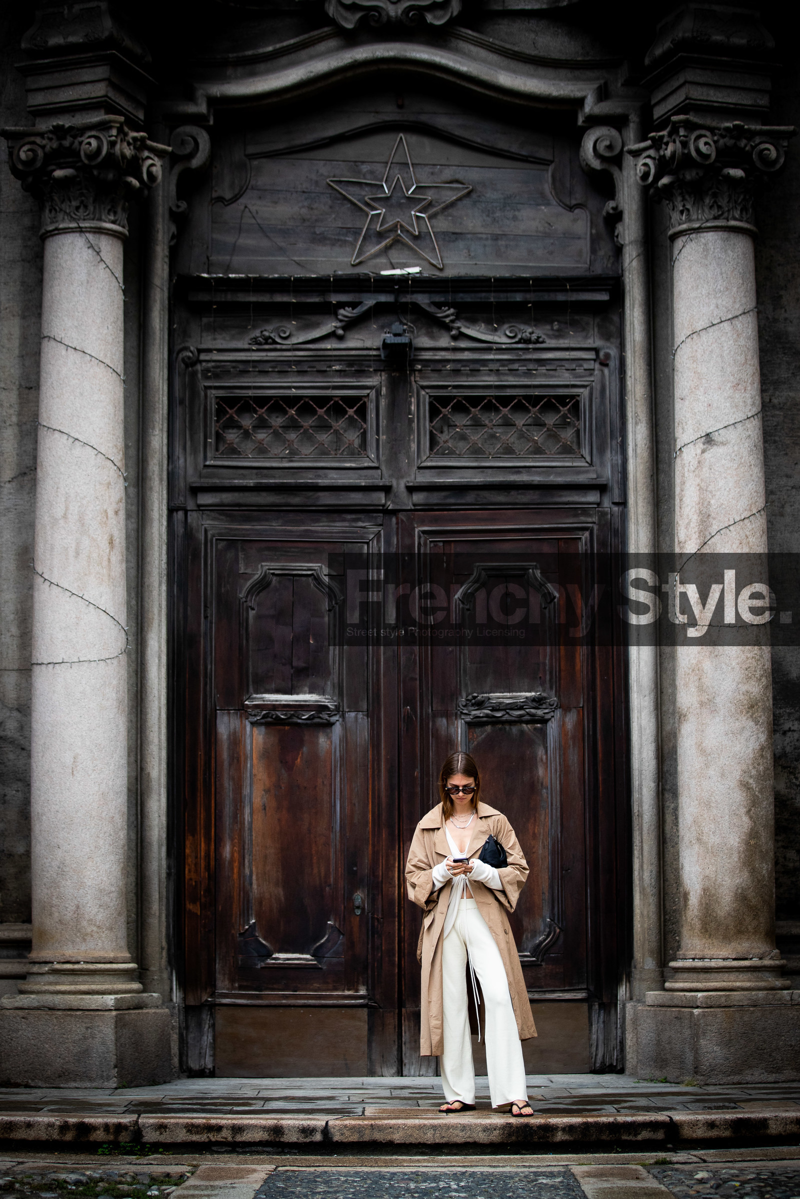 beige trench coat, camel trenchcoat, white top, white pants, knit pants, knitwear, laced top, asymmetrical top, cropped top, scale sunglasses, bottega veneta sunglasses, black sandals, flat sandals, flip flop shoes, silvered necklace, multi necklace, jacqueline zelwis, street style, jonathan paciullo, FW, frenchystyle, fashion week, MFW, MILAN, SPRING SUMMER 2021, SS 21, vertical, full length