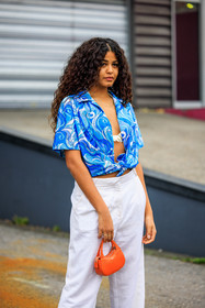 curly hair, blue shirt, printed shirt, coperni shirt, white bra, white trousers, baggy trousers, orange bag, mini bag, coperni, street style, jonathan paciullo, FW, frenchystyle, fashion week, AUTUMN WINTER 2022-2023, FALL WINTER 2022_2023, FW 22-23, PFW, PARIS, vertical, detail