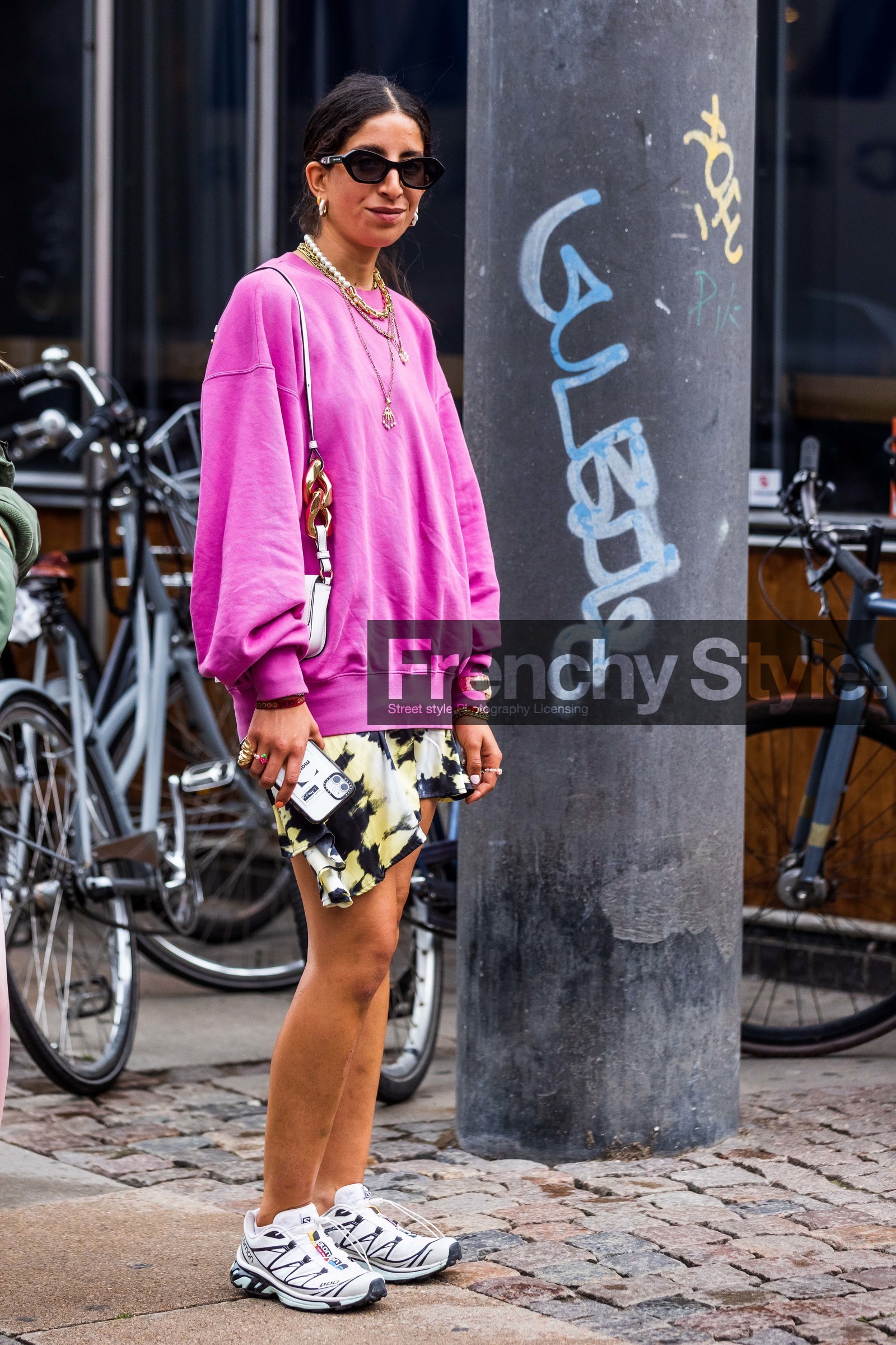 Selma Kaci, pink sweatshirt, fushia sweatshirt, printed skirt, mini skirt, white leather bag, shoulder bag, j w anderson bag, chain strap bag, multi necklace, pearl necklace, golden necklace, long necklace, multi earrings, lucky charm necklace, lucky charm bracelet, baby g watch, chain necklace, the kooples sunglasses, black sunglasses, tie and dye skirt, white sneakers, white leather sneakers, salomon sneakers, fashion week, frenchystyle, FW, jonathan paciullo, street style, SPRING SUMMER 2022, SS 22, COPENHAGEN, CPHFW, vertical, full length