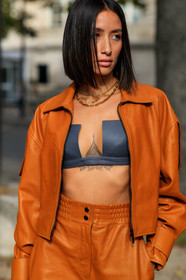 alexandra guerain, orange leather jacket, orange leather pants, orange total look, zipped jacket, black bra, cropped top, low necked top, black leather top, multi necklace, chain necklace, letters necklace, golden necklace, PARIS, PFW, SPRING SUMMER 2020, SS 20, fashion week, frenchystyle, FW, jonathan paciullo, street style, vertical, atmosphere details, detail
