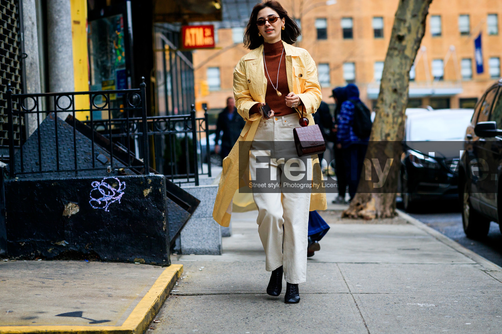 black shoes, brown bag, brown sweater, denim pants, jeans, leather bag, leather shoes, necklace, sunglasses, trousers, white denim, yellow coat, frenchystyle, jonathan paciullo, street style, NYFW, NEW YORK, AUTUMN WINTER 2019-2020, AW 19-20, FALL WINTER 2019-2020, FW 19-20, fashion week, FW, atmosphere details, horizontal, full length